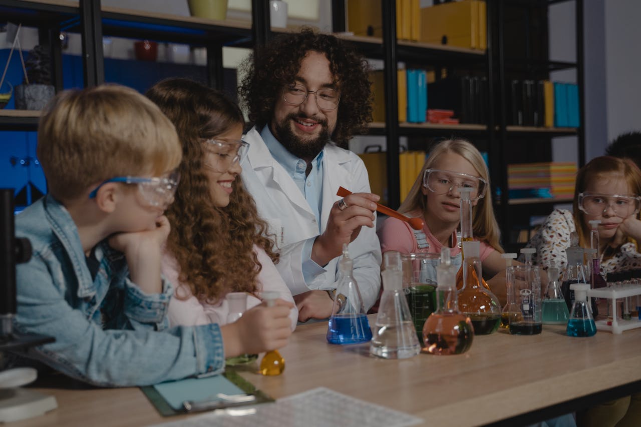 Students in a science class watch a chemistry experiment with colorful liquids.